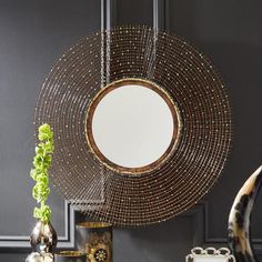 a table topped with vases and a round mirror