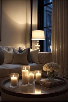 candles are lit on a coffee table in the living room