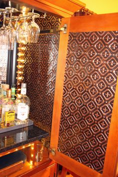 an old fashioned liquor cabinet with wine glasses and bottles on it's side shelf