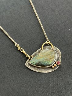 This unique piece has a very special labradorite gemstone which resembles a multi-colour leaf. It is absolutely unique in every way. Keep in mind:  Our products are handmade. All our artisan crafted products are made from 925 sterling silver which require polishing from time to time from oxidation. You can quickly restore silver to shine with a polish cloth. Please, avoid contact with cosmetics and chemicals. Don't wear it in the shower, pool, spa or the beach. **For shipment information, please Unique Labradorite Pendant Jewelry, Unique Labradorite Teardrop Pendant Jewelry, Bohemian Sterling Silver Necklace With Natural Inclusions, Unique Labradorite Gemstones For Jewelry Making, Unique Leaf-shaped Jewelry For Jewelry Making, Untreated Labradorite For Jewelry Making, Unique Oval Labradorite Necklace, Hand Forged Labradorite Teardrop Jewelry, Artisan Jewelry With Labradorite Oval Pendant