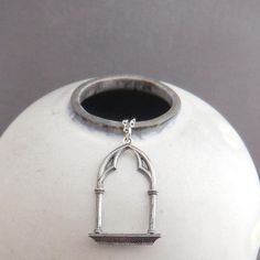 sterling silver gothic window frame necklace, 1 1/8"  - A solid sterling silver pendant, measuring 1 1/8" (29 mm) down, 3/4" (17 mm) across.  - Necklace is 1.5 mm sterling silver cable chain, length customizable at drop down menu. Lobster clasp and locking jump rings, all solid sterling silver.  - Details blackened (oxidized), back is concave, with 925 mark. - With sustainability in mind, charm is made from 100% post-consumer recycled sterling silver. - Packaged in a modern circular tin, ready for gift giving, and comes with a silver polish pad and care instructions. Customize chain length or "charm only" option: - Charm only option, no chain. Charm does include a top ring. - Chain length: Choose a set length from the drop down menu or choose "Other" and leave a note in the box at checkout Gothic Window Frame, Gothic Window, Medieval Necklace, Frame Necklace, Architect Gift, Gothic Windows, Medieval Architecture, Replica Jewelry, Silver Polish