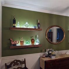 two shelves with liquor bottles on them are next to a dresser and mirror in a room