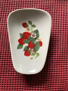 a white bowl with strawberries painted on it