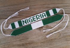 two green and white knitted ties with the word michigan on them sitting on a wooden surface