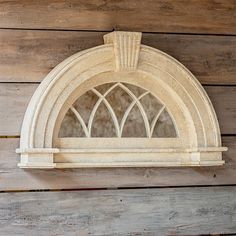 an arched window on the side of a wooden wall