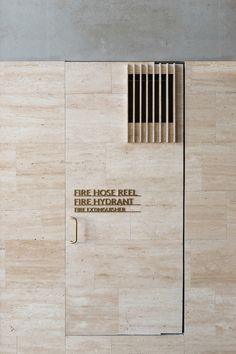 the entrance to fire department building is made out of wood and has an iron grate on it