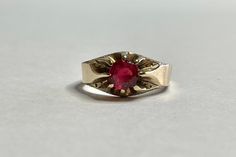 Stunning antique circa 1910s Edwardian era 10k yellow gold red tourmaline ring! This timeless statement ring has a 10k yellow gold belcher style setting. In the center is a round faceted red tourmaline gemstone, that is approximately .84 carats. The red stone is securely prong set, and there are small etched designs down the shoulders. A fantastic piece of fine unisex style jewelry, from the early 1900s! ERA - Circa 1910s / Edwardian METAL / MATERIAL - 10k yellow gold, red tourmaline (approx. .8 Antique Red 14k Gold Signet Ring, Antique Red Signet Ring In 14k Gold, Antique Ruby Ring Hallmarked, Vintage Ruby Gold Rings, Vintage Hallmarked Ruby Ring For Formal Occasions, Vintage Round Gemstone Signet Ring, Vintage Gemstone Signet Ring, Heirloom Ruby Signet Ring With Hallmark, Antique Ruby Signet Ring