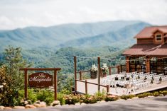 an outdoor venue set up with tables and chairs for guests to sit on the mountain side