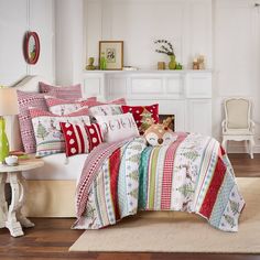 a bed with red and white comforters in a room