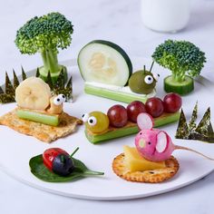 a plate topped with different types of food on top of a white table next to broccoli and cucumbers