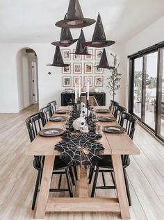 a dining room table decorated for halloween with black and white decorations