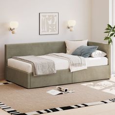 a bed sitting on top of a rug in a bedroom next to a wall mounted light