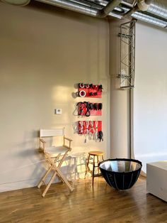 a room with two chairs, a table and a wall mounted art piece on the wall