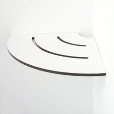 a white shelf with curved black lines on the top and bottom, against a white wall