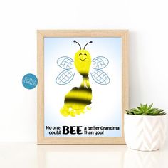 a framed poster with a bee on it next to a potted plant