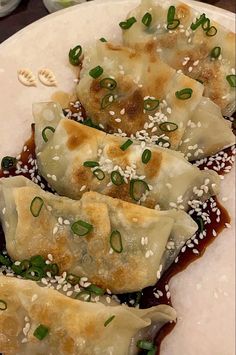 dumplings with sauce and sesame seeds on a plate