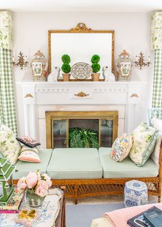 a living room filled with furniture and a fire place under a mirror on the wall