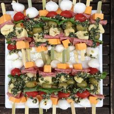 several skewers filled with different types of food on toothpicks and vegetables