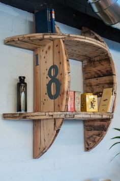 a wooden shelf with books on it and a clock mounted to the wall behind it