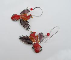 This pair of colorful Cardinals will have you ready to lend an ear for each is made of sterling silver with vibrant, cloisonné enamels and sports a red, Swarovski crystal atop each wing for added interest. Each earring measures 1.5 inches in length from the French hook ear wire to the bird's wingtip and is .75 inch in width from beak to tail. You'll find them to be in excellent, like new condition and although the back is covered with enamel they are guaranteed to be of sterling character. Even Red Enamel Pierced Earrings, Handmade Red Enamel Jewelry, Red Pierced Enamel Earrings, Collectible Enamel Jewelry With Matching Earrings, Red Hand Painted Sterling Silver Jewelry, Red Enamel Collectible Jewelry, Red Enamel Earrings, Red Enamel Drop Earrings, Peacock Ring