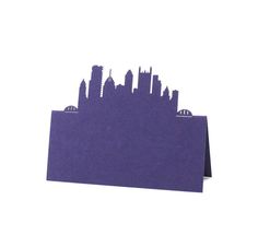 a city skyline cut out of purple paper