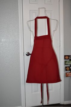 a red apron hanging on a white door