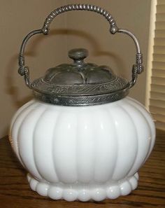 an antique white glass covered tea kettle