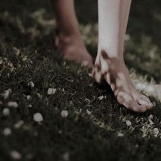 a person standing in the grass with their bare feet