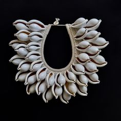 Elevate your style with the White Ovula Ovum (White Egg Cowrie) Shell Necklace, a captivating piece of tribal fashion hailing from the rich traditions of Papua New Guinea. This exquisite necklace is more than just an accessory; it's a wearable work of art that seamlessly marries cultural heritage with contemporary women's fashion. Each meticulously selected Ovula shell in this necklace reflects the timeless craftsmanship of Papua New Guinean artisans. The soft, iridescent white shells, delicatel Elegant Handwoven Natural Jewelry, Elegant Handwoven Jewelry, Elegant White Jewelry For Rituals, Unique Beaded Natural Jewelry, Traditional Handwoven Natural Jewelry, Unique Natural Beaded Jewelry, Traditional Handwoven Natural Color Jewelry, Traditional Shell Necklace Gift, Traditional Natural Jewelry For Rituals