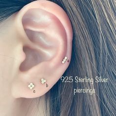 an ear with three small flowers on it and the words 925 sterling silver piercings