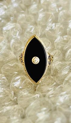 Antique Art Deco Ladies Marquis Ring.  14 K White and Yellow Gold.  Black Onyx with European cut diamond stone set in center.  Sleek, slender and stylish.  Beautiful hexagonal shape with open floral filagree on both sides.  Representing the most perfect example of the art deco period.  Good condition.  Normal wear.  Ladies size 5.  Can be resized.  Stone measures 7/8" Long. Elegant Evening Diamond Ring With Gemstone, Elegant Black Diamond Ring In 14k Gold, Elegant Gemstone Rings For Evening, Elegant Oval Evening Rings, Elegant 14k Gold Diamond Ring For Evening, Formal Black Enamel Fine Jewelry Rings, Elegant Black Enamel Rings For Evening, Formal Onyx Diamond Ring Fine Jewelry, Elegant Oval Black Enamel Jewelry