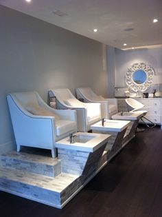 a row of white chairs sitting on top of a hard wood floor