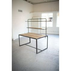 an empty room with a wooden table and metal frame on the floor in front of a window