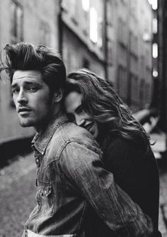 a man carrying a woman on his back in an alleyway, black and white photo