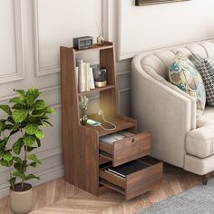 a living room with a couch, chair and book shelf next to a potted plant