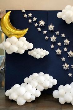 the balloon wall is decorated with stars, moon and cloud shapes in white on a dark blue background