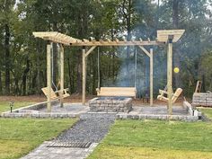 an outdoor fire pit with swings and benches