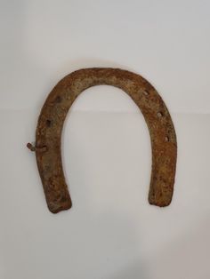 an old horseshoe shaped object on a white surface