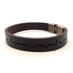 "This bracelet is made of genuine real leather and can be personalized on the outside, inside or both sides with your own wording in Morse Code. Simple stunning look with your secret morse code message just for you. This bracelet is lightweight, customizable and can be worn for any occasion. It is a stylish fashion piece for both men and women and makes a unique gift. Details :  * 3/8\" Genuine Leather Band * Red Copper Antique Clasp * To maintain the quality and the beauty of your leather piece, we recommend to avoid getting it wet. Engraving Information :  * I can engrave up to 60 characters including spaces on each side of the leather band. * This bracelet is 100% completely customizable with anything in morse code with anything you might have in mind... dates, special messages, bible v Adjustable Engraved Leather Bracelet, Adjustable Rectangular Leather Wristband, Adjustable Leather Rectangular Wristband, Everyday Engraved Brown Leather Bracelet, Everyday Brown Engraved Leather Bracelet, Rectangular Leather Bracelet As A Gift, Personalized Brown Leather Bracelets, Rectangular Leather Bracelet For Gift, Leather Wristband Gift