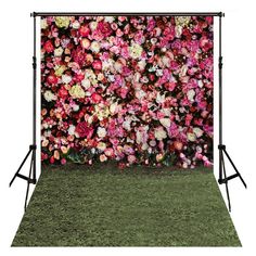 the backdrop is made up of pink and white flowers, with green grass in front