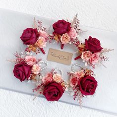 flowers are arranged in the shape of a wreath on a white tablecloth with a name tag