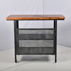 a wooden table sitting on top of a white floor next to a black metal frame