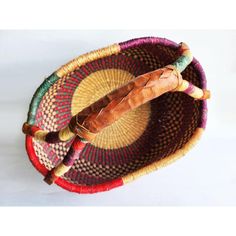 two small round baskets with wooden handles on white table top, one is holding an umbrella and the other has a stick in it