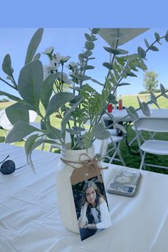 a vase filled with flowers sitting on top of a white table cloth covered tablecloth