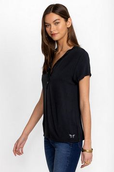 Crafted from a super soft modal blend with a hint of stretch, the Modal Jersey Button Neck Tee offers a modern take on classic sportswear. Featuring a curved V-neckline with decorative buttons, this short sleeve tee creates a relaxed fit with a custom feel. Pair with linen shorts and fashion sneakers to take on the warmest days. Johnny Was Women's Modal Jersey Button Neck T-Shirt in Black Beauty White, Size Small, Linen Casual Modal T-shirt, Casual Stretch Top With Henley Neckline, Casual Henley Neckline Tops With Stretch, Casual Modal Top With Relaxed Fit, Casual Modal Tops For Loungewear, Stretch Henley Neckline Top For Loungewear, Black Relaxed Fit Top In Modal, Black Relaxed Fit Modal Top, Casual Modal Tops For Layering