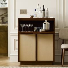 a cabinet with wine glasses and bottles on it