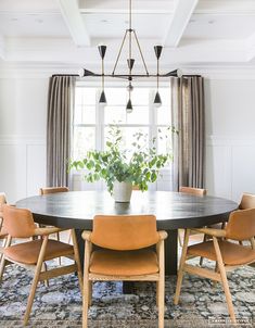 a dining room table with chairs around it and a potted plant on the table