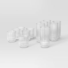 a set of eight clear glass tumblers on a white surface with no one in the photo