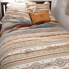 a bed with a colorful comforter and pillows