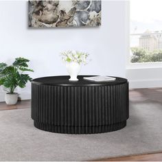 a black coffee table sitting on top of a rug in front of a white wall